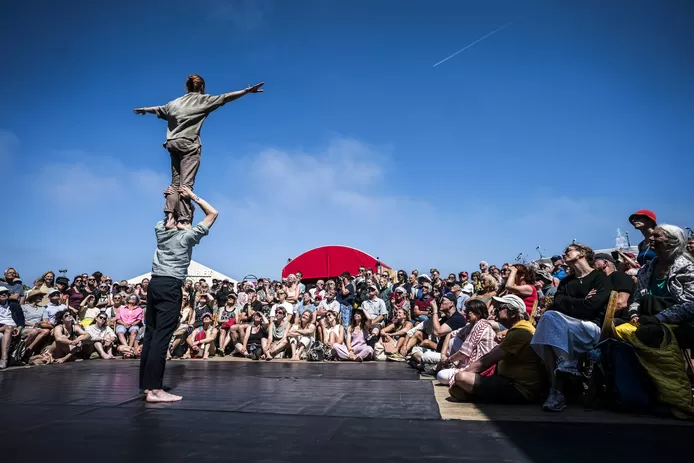 Mimespelers en acrobaten De Ronde/DeRoo tijdens hun straattheatervoorstelling op festivalhart de Deining tijdens Oerol 2023.