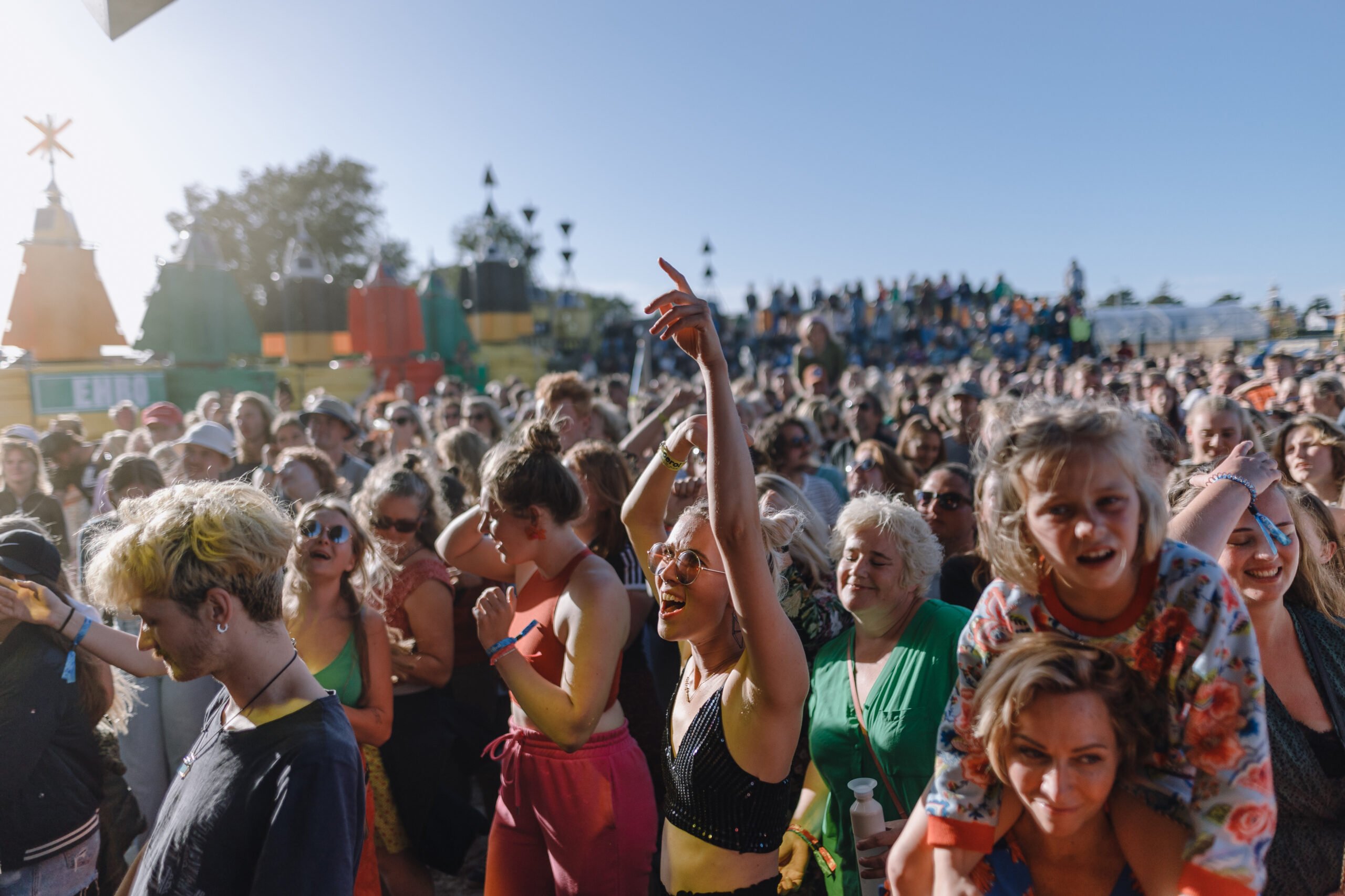 Dansende mensen bij het optreden van zangeres Merol op festivalterrein de Betonning tijdens Oerol 2022