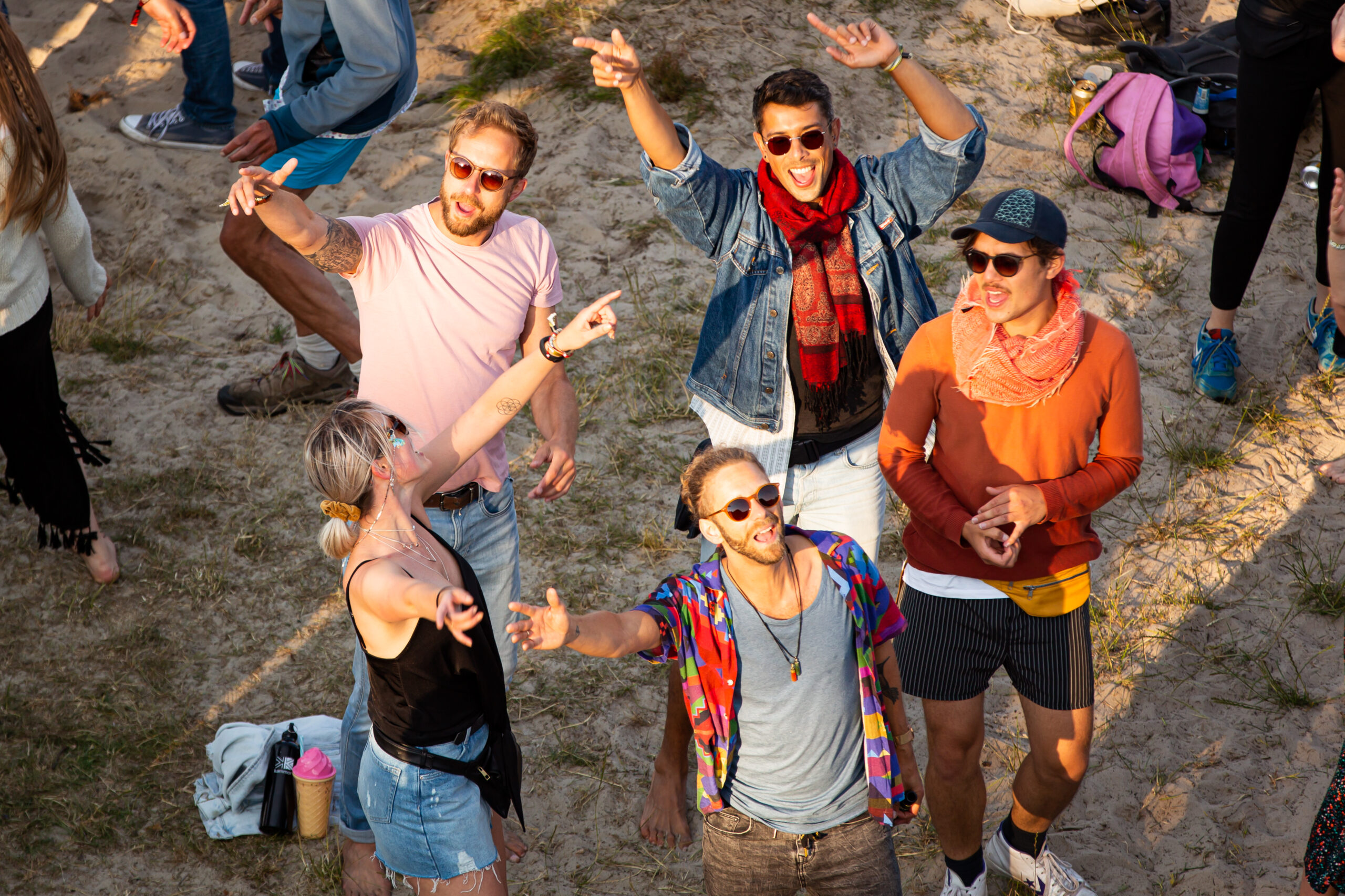 Vier mannen en een vrouw dansen tijdens een pop-up feestje aan het Duinmeertje van Hee tijdens Oerol 2019
