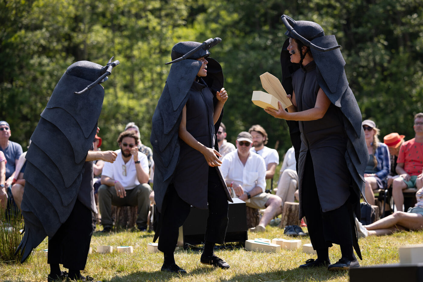 Drie door mensen gespeelde torren met een doodskist uit de theatrale ceremonie Herinner Ons van theatergroep Gouden Haas, gespeeld op Oerol 2023.