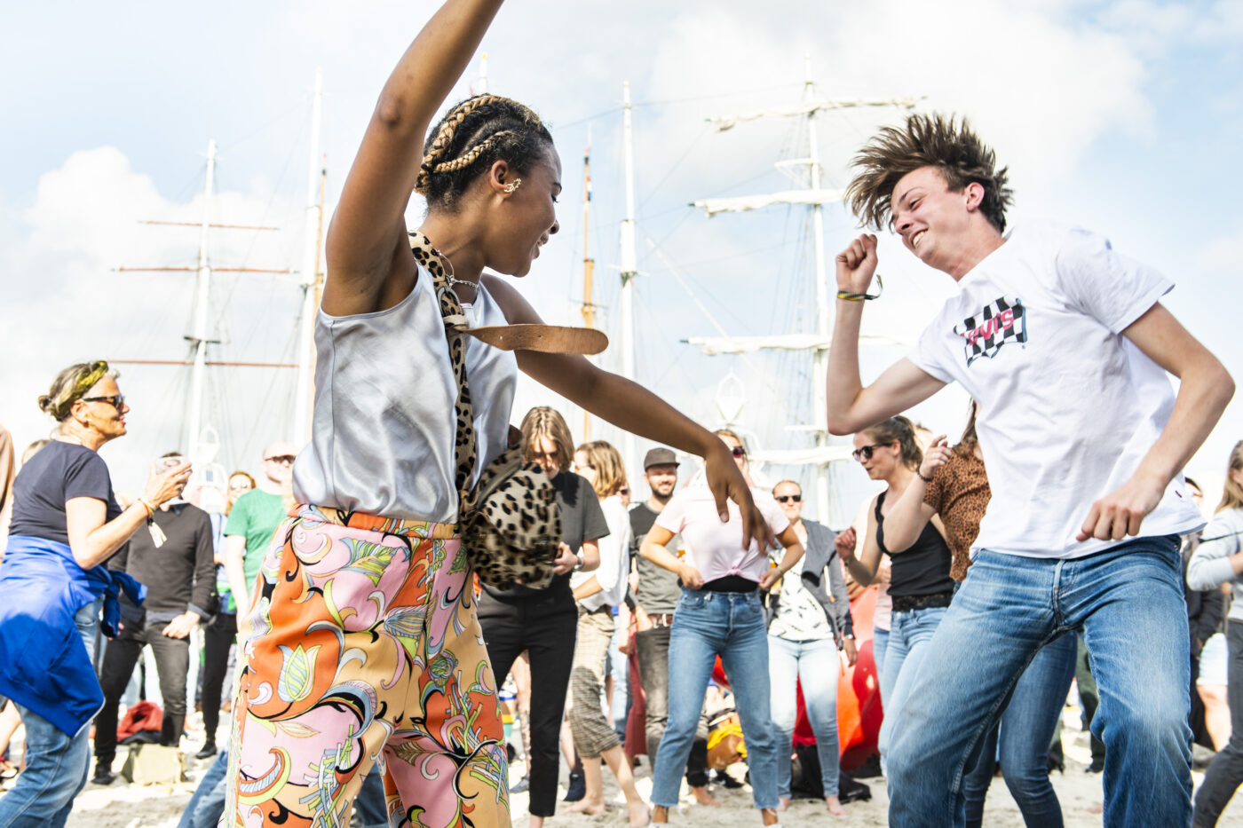 Twee jonge mensen dansen op de muziek van KD Soundsystem op voormalig festivalterrein de Betonning tijdens Oerol 2019