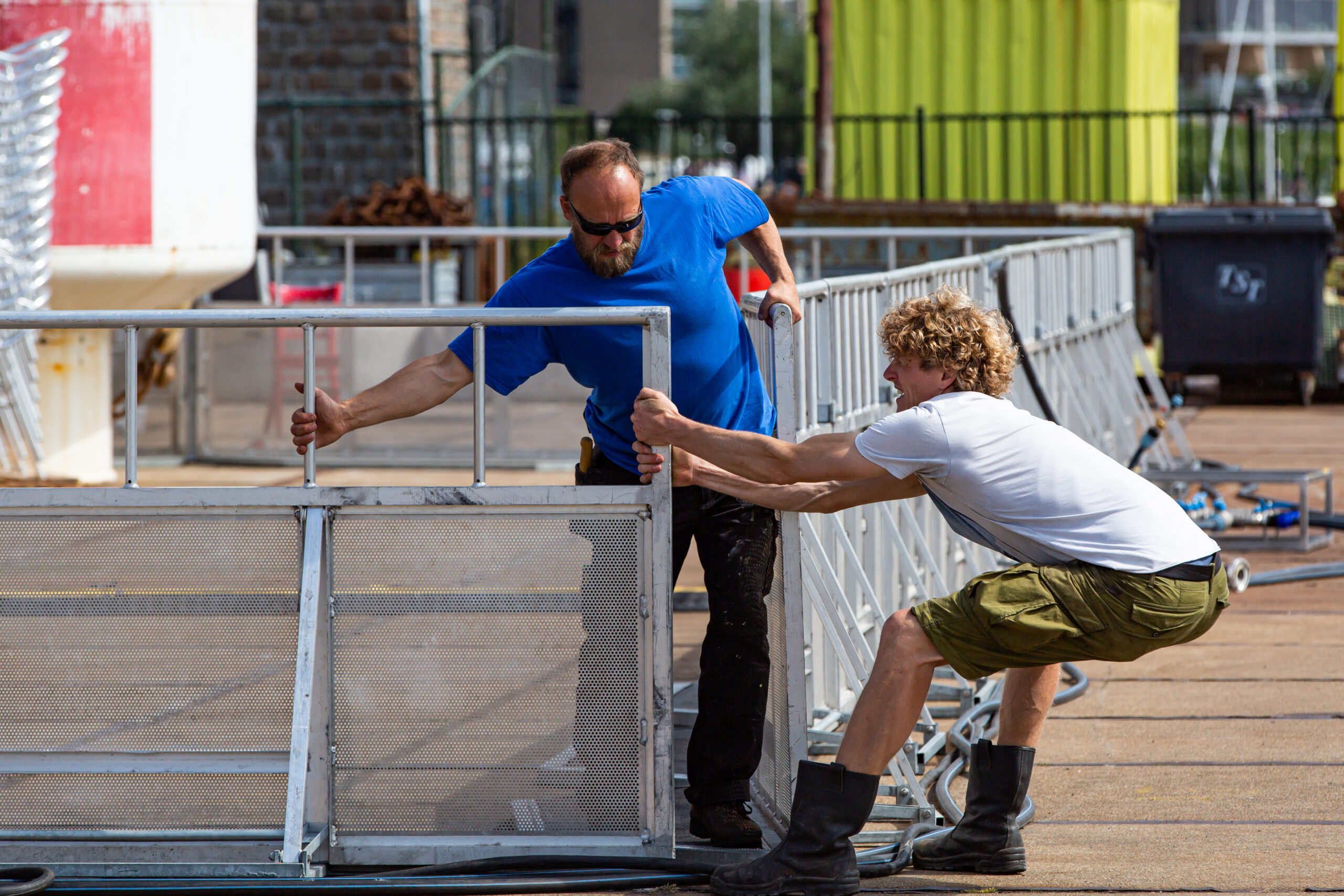 Twee mannen bouwen hekken op voormalig festivalterrein de Betonning op Oerol.