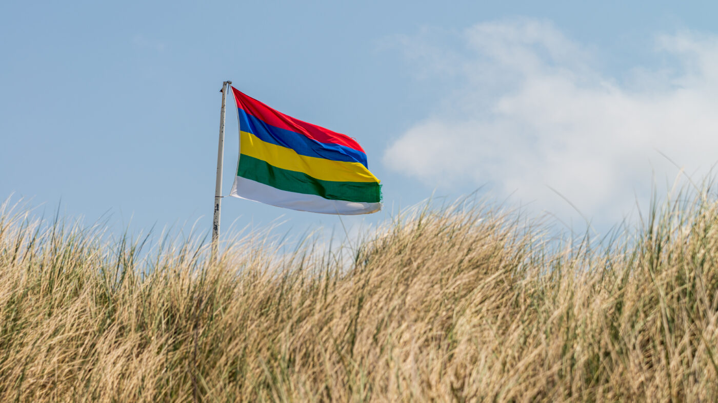De Terschellinger vlag met haar 5 kleuren wapperend boven het duin.
