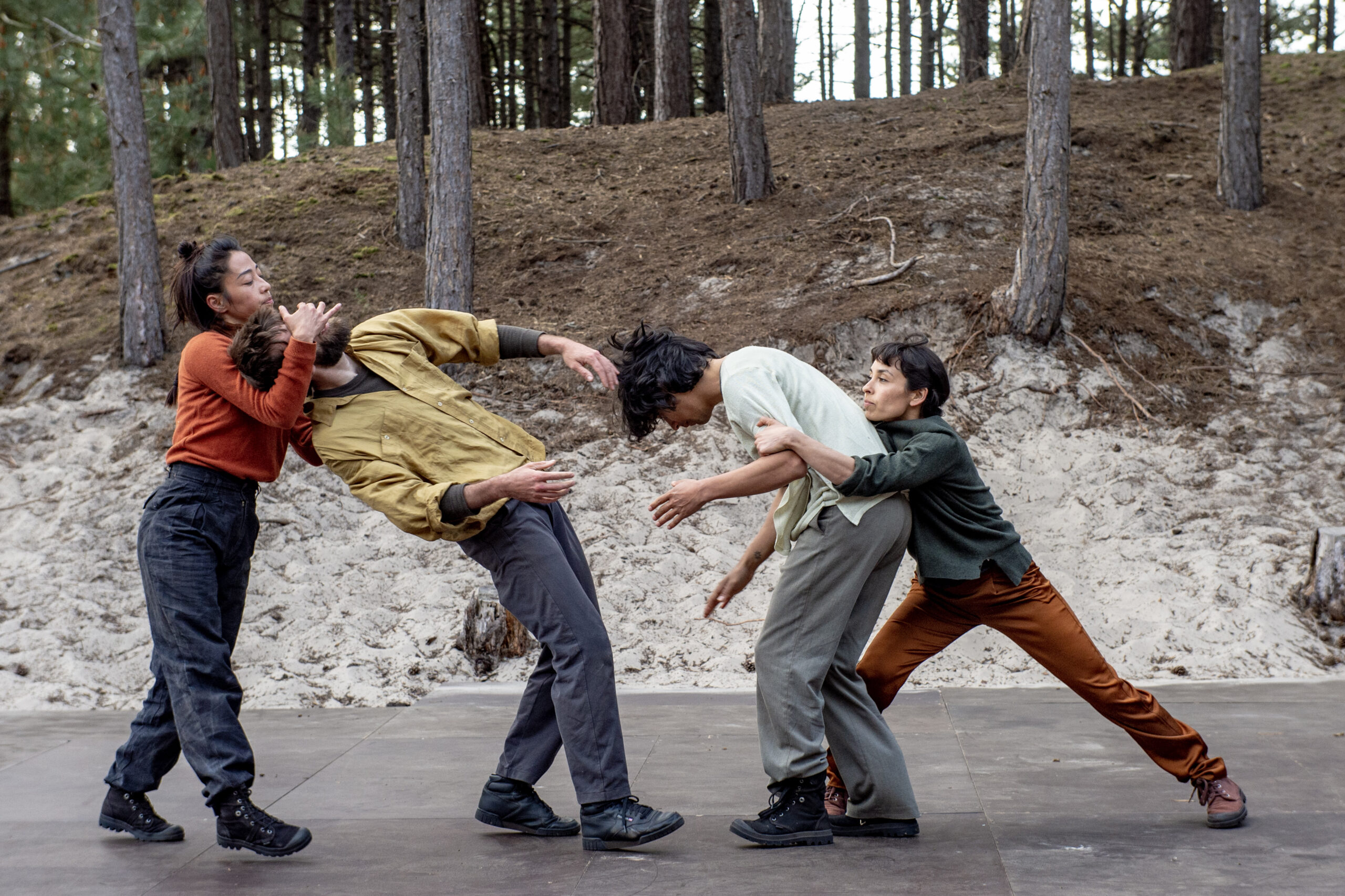 vier dansers dansen in een zandafgraving in het bos, een voorstellingsbeeld uit de dansvoorstelling Hush van theatergezelschap De Dansers, Oerol 2023